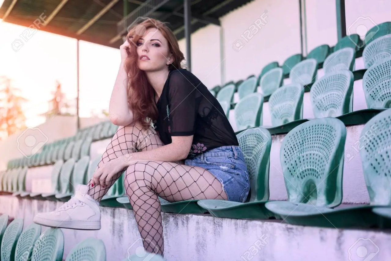 101691782-redhead-girl-sitting-on-a-slipway-with-fishnet-stockings.jpg