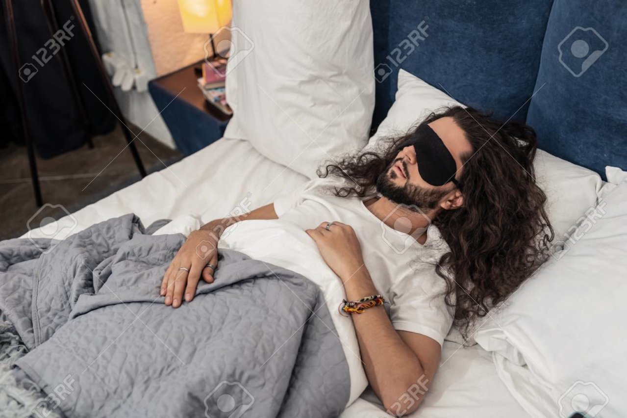 118437819-time-to-sleep-nice-bearded-man-wearing-a-special-sleeping-mask-while-lying-in-the-bed.jpg
