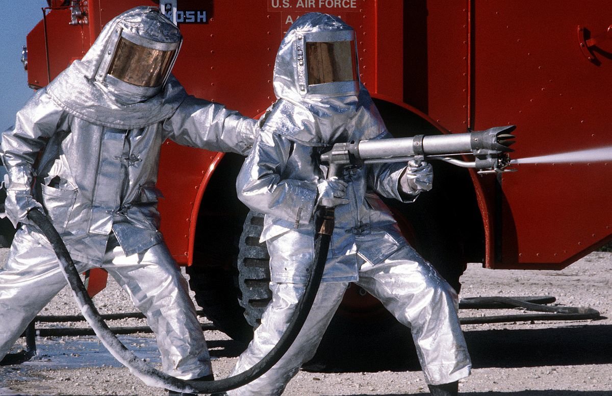 1200px-Fire_fighters_practice_with_spraying_equipment,_March_1981.jpg