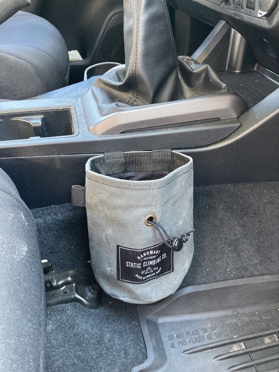 Seeing a lot of people talking about larger water bottles not fitting in  the cup holders. I present to you the chalk bag from REI. Easy to install.  Holds just about any