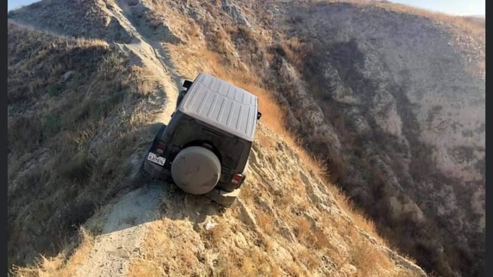 a-jeep-wrangler-is-hanging-off-a-mountain-ridge-on-a-narrow-bike-trail_2.jpg