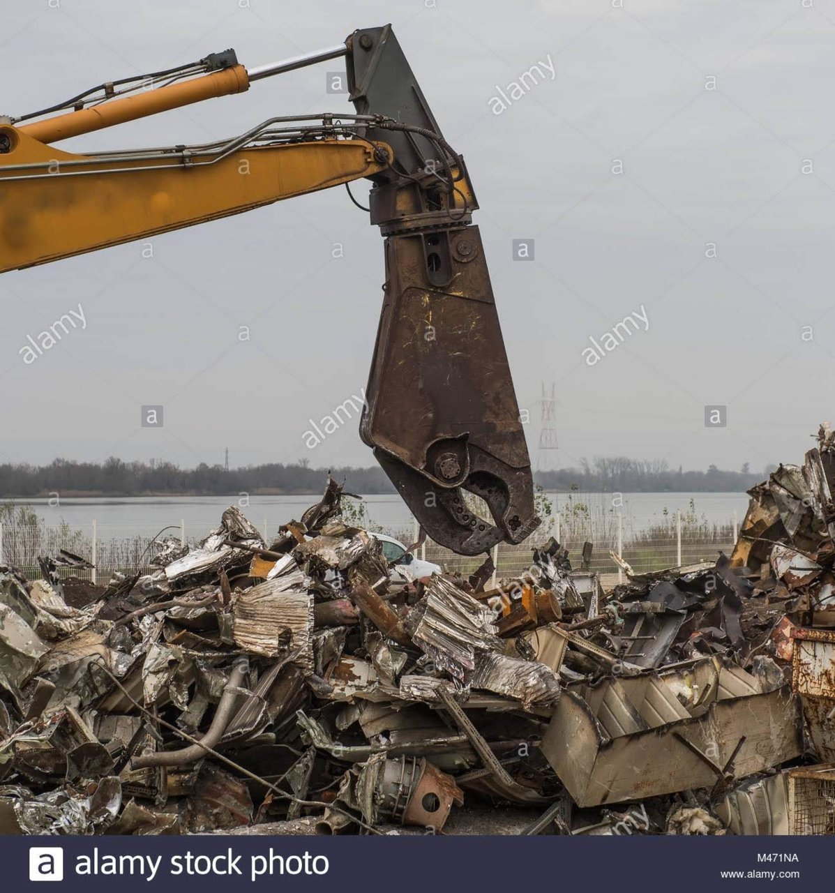large-tracked-excavator-working-a-steel-pile-at-a-metal-recycle-yard-M471NA.jpg