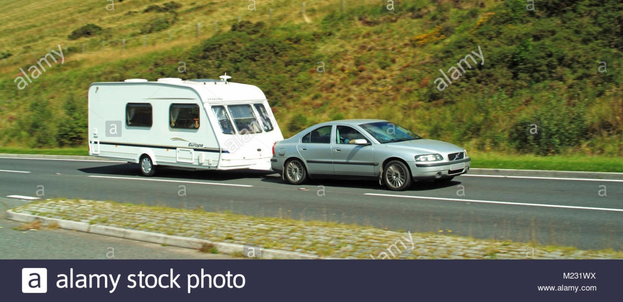 man-driving-car-towing-caravan-on-rural-scenic-countryside-road-in-M231WX.jpg