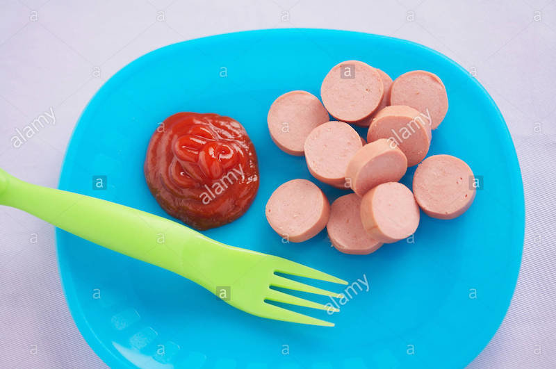 sliced-hot-dog-with-ketchup-and-a-plastic-fork-on-blue-plastic-plate-X9B8T0.jpg