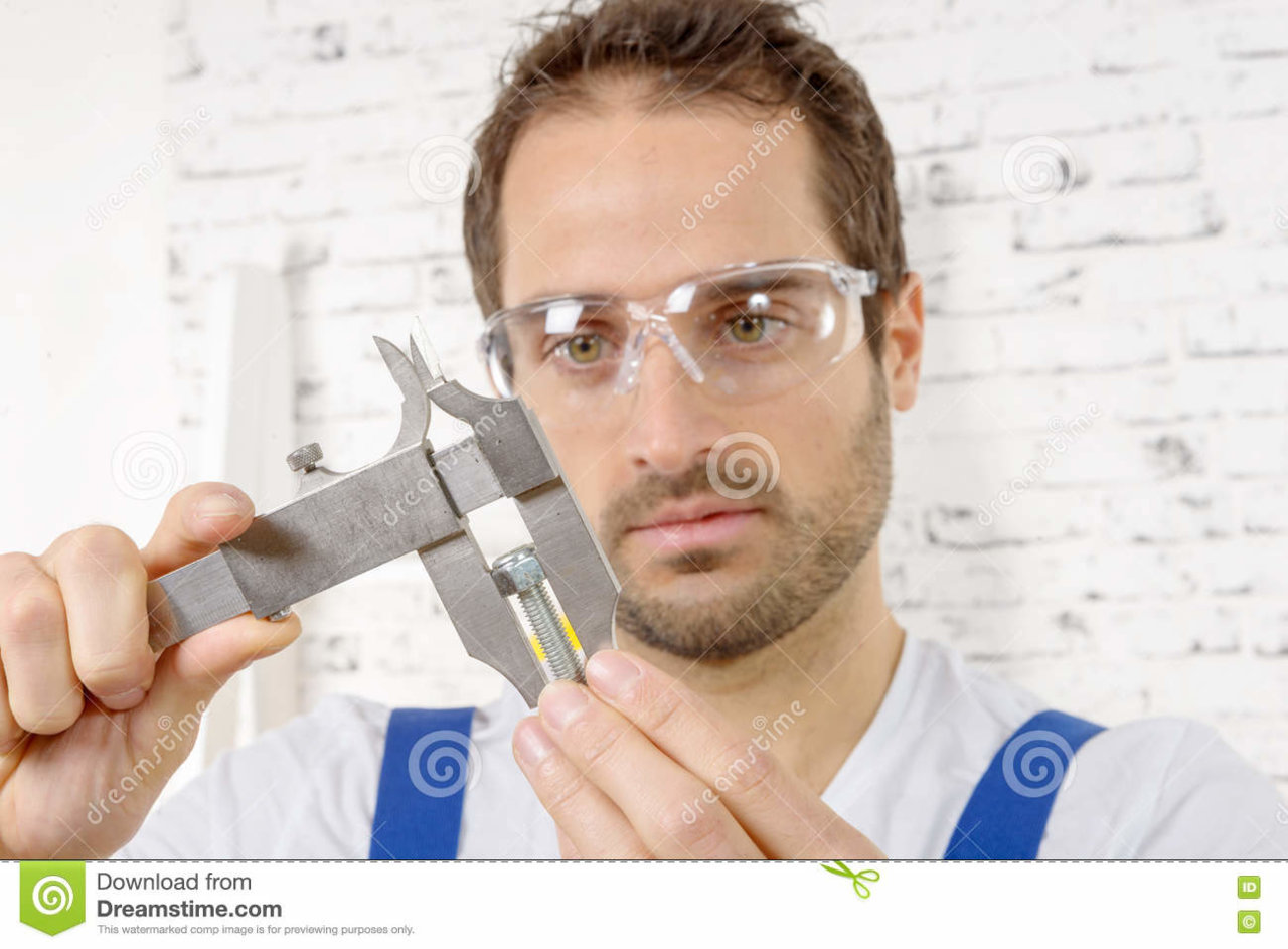 young-man-measuring-screw-using-caliper-71150513.jpg