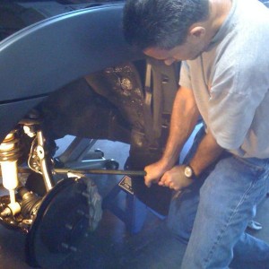 pry down lower control arm to fit strut