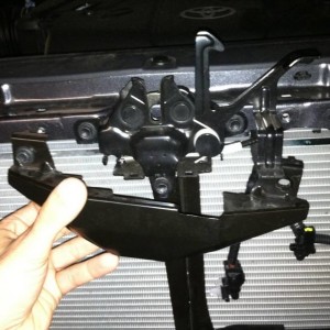 Removing the hood latch cover to prep for behind the grill light bar.