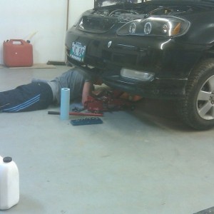 My little brother atempting to change his oil.(with dads help) thinks oil l