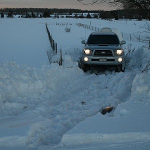 Tacoma trailering snowmobile out of snow lot