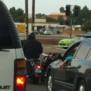 Golf clubs as a bag on the right of his bike.