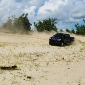 {;aying in the sand