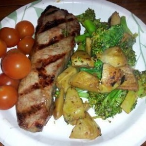 New York strip with tomatoes and garlic broccoli and artichoke hearts.