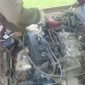 Jasmine replace spark plugs and wires on her girlfriends car