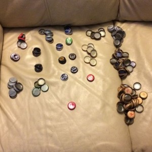All the diferent types of beer caps I have. Biggest pile on bottom right in
