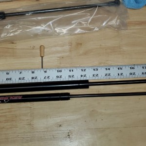 2 inches longer, 9 lb more pressure, larger diameter rod and piston steel vs nylon ball claw connector, attaching by rivnut M5 .8 machine vs 1/4 20 co